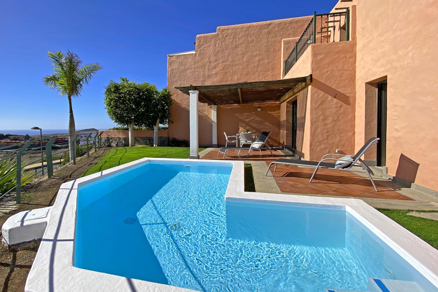 Vivienda de dos dormitorios con bonita zona de jardín, piscina privada y comunitaria y vistas al campo de golf, el mar y las montañas