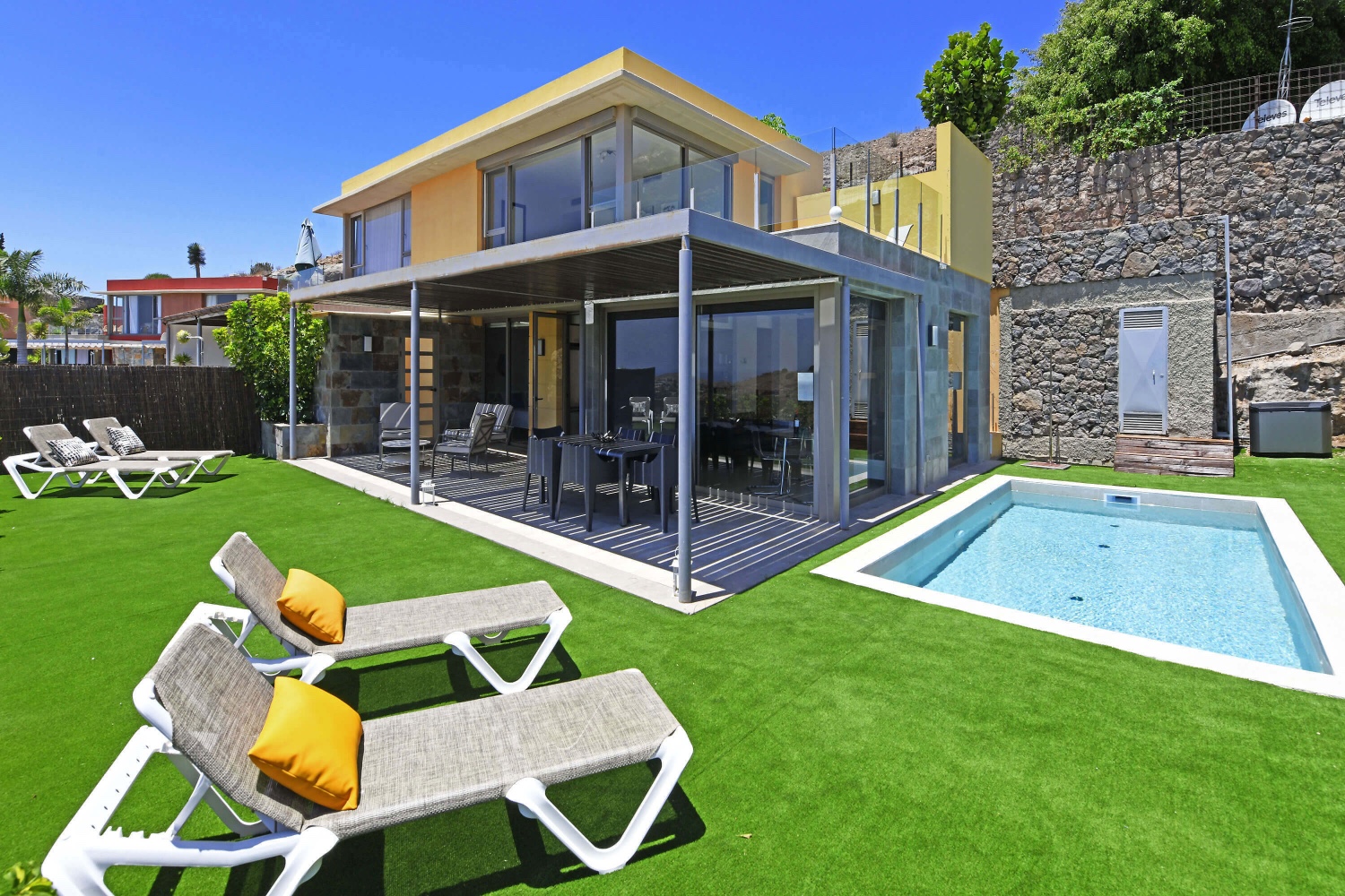 Zweistöckiges Haus mit modernem Design, großen Glasfenstern und einem angenehmen Außenbereich mit privatem Pool