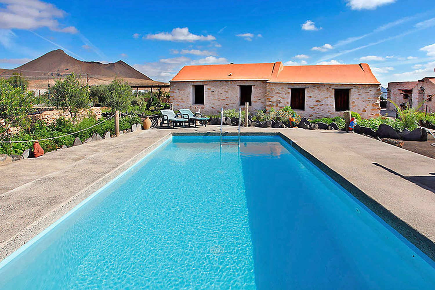 Et feriehus med rustikk felles svømmebasseng i en omfattende eiendom i vakre omgivelser
