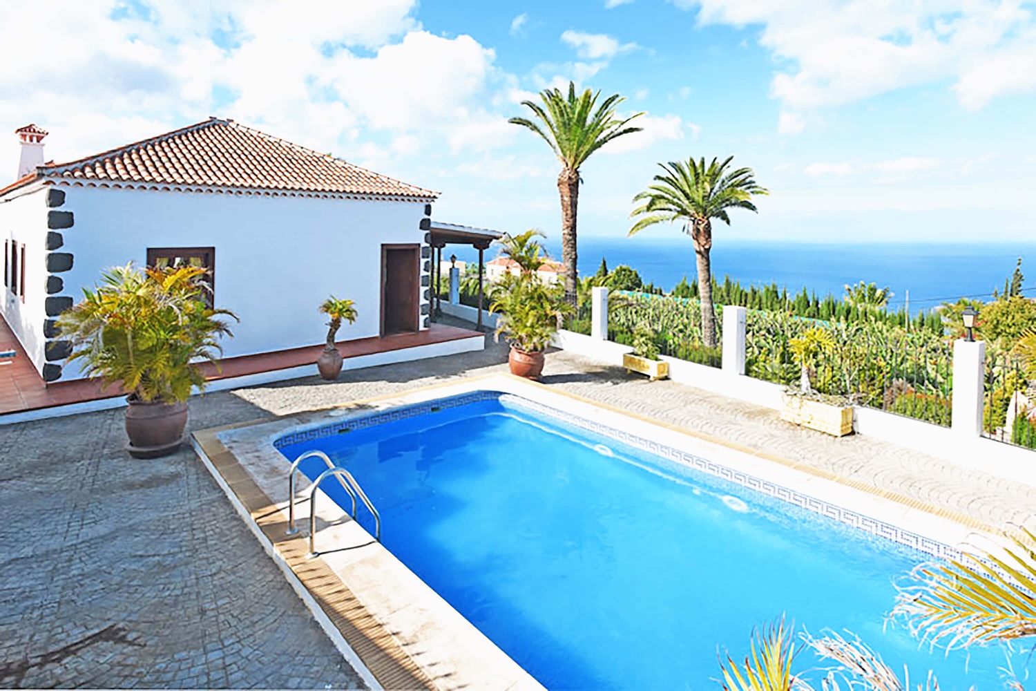 Elegant semesterhus omgivet av palmer med en stor uteplats, privat pool och fantastisk havsutsikt